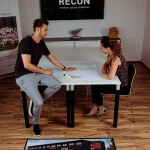Rohož JET PRINT PATIO s farebnou grafikou budovy a logom RECON pred stolom v kancelárii