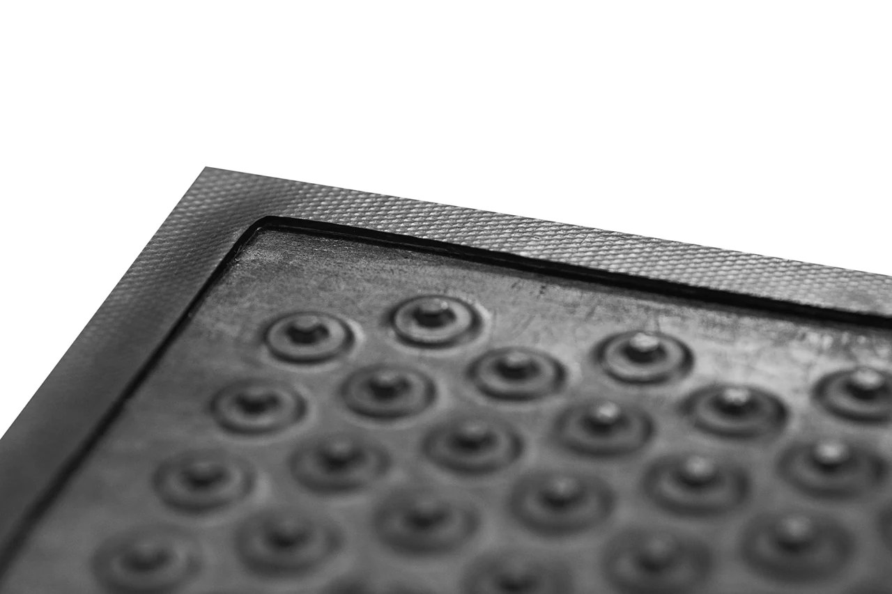 Detail čiernej rohože KLEEN COIL s kruhovými výstupkami a profilovaným okrajom