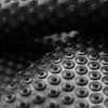 Detail ohnutej čiernej rohože KLEEN COIL s pravidelnými kruhovými výstupkami