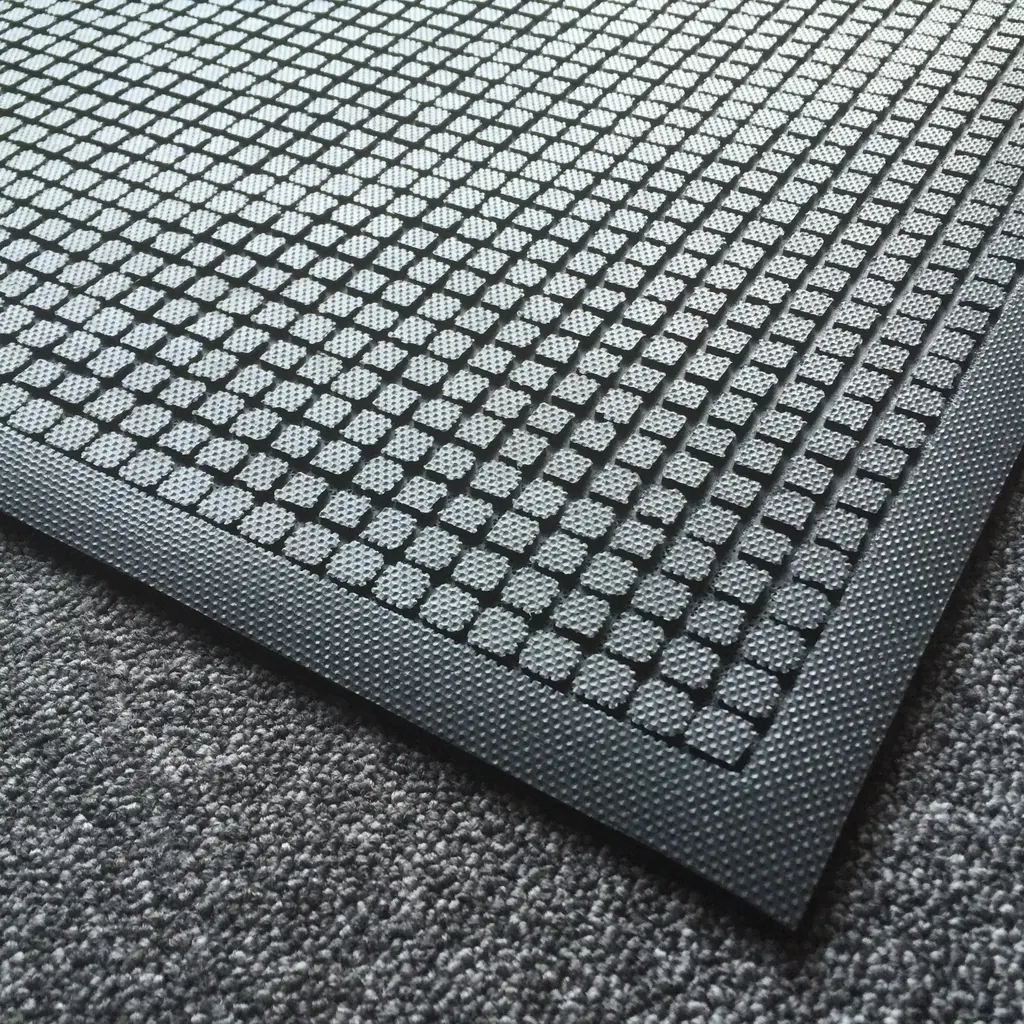 Detail vyvýšených štvorcových prvkov a štruktúrovaného okraja čiernej rohože KLEEN CUSHION