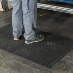 Detail pracovnej obuvi na čiernej profilovanej rohoži KLEEN CUSHION pri zariadení