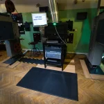 Čierna rohož KLEEN CUSHION na drevenej podlahe pred zariadením s monitorom