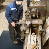 Pracovník stojaci na rohoži KLEEN SCRAPE pri obsluhe stroja