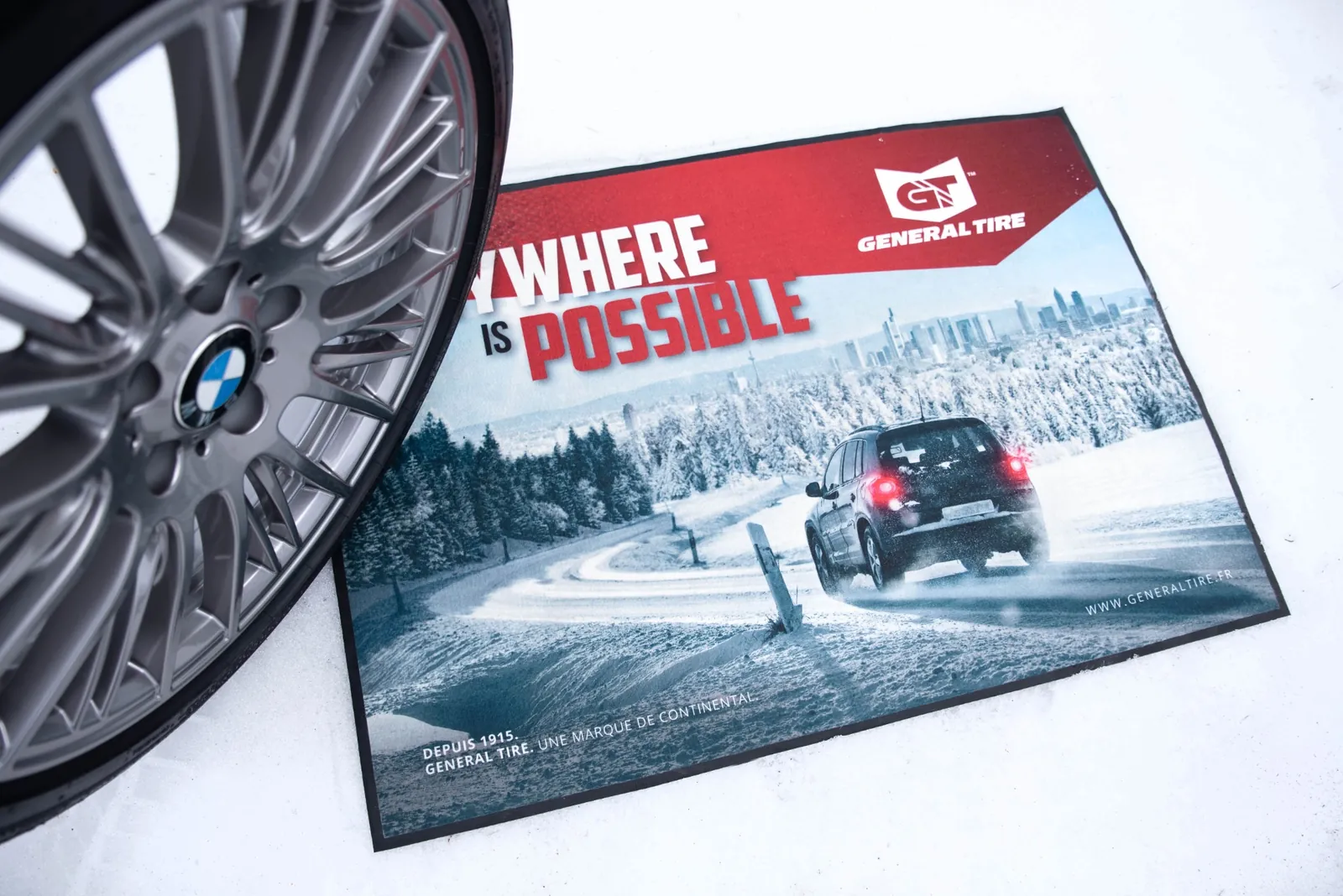 Reklamná rohož SUBLI MAT s logom GENERAL TIRE a fotografiou auta na zasneženej ceste vedľa kolesa
